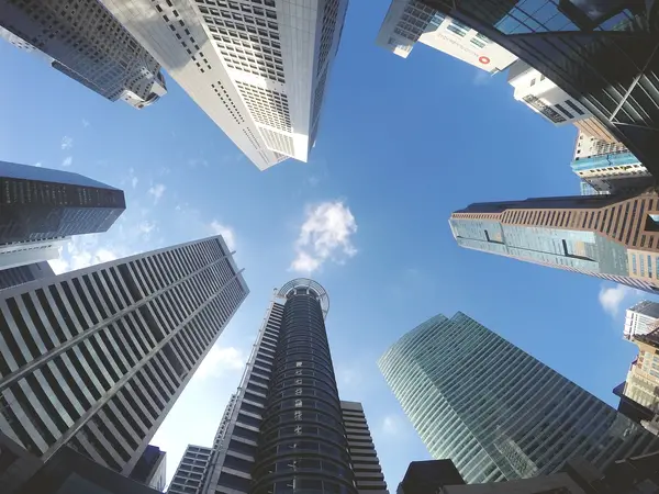 View of towering skyscrapers against clear blue sky, showcasing urban architecture and the significance of commercial real estate