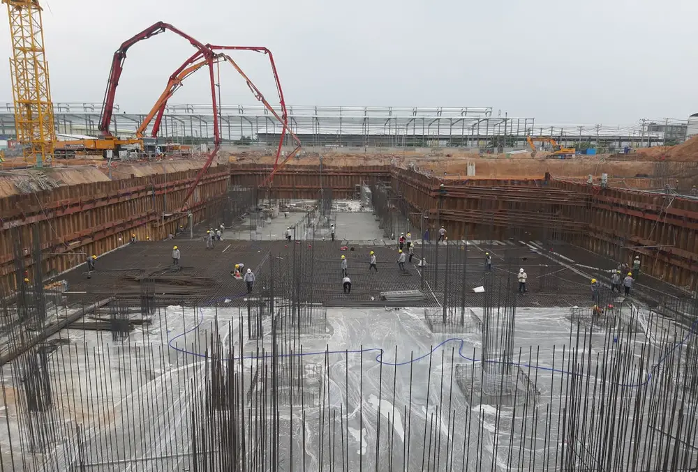 Construction site with excavation, rebar, and machinery, emphasizing the need for construction site security guard