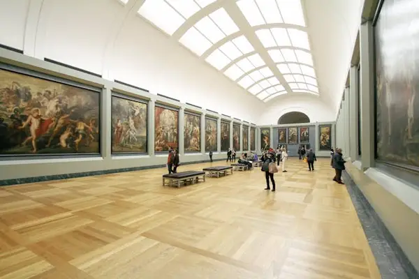 Interior of art gallery with vaulted ceiling and framed paintings, highlighting the need for security guard services in cultural properties