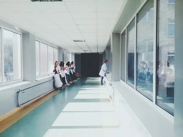 Bright hospital corridor with healthcare professionals in lab coats, emphasizing the need for security guard services in medical facilities