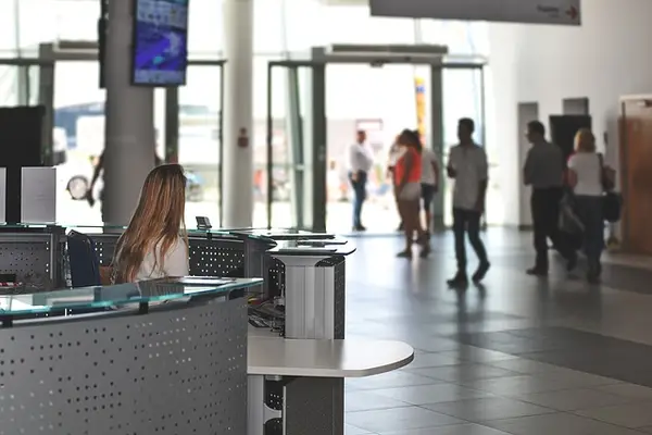 Individual at counter in public space with computer terminals, highlighting the need for security guard services in local government offices