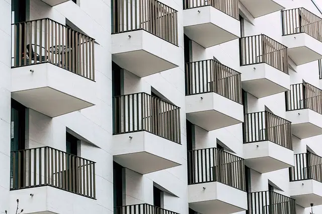 New York City Guard - Modern white apartment building with balconies, highlighting residential building security services