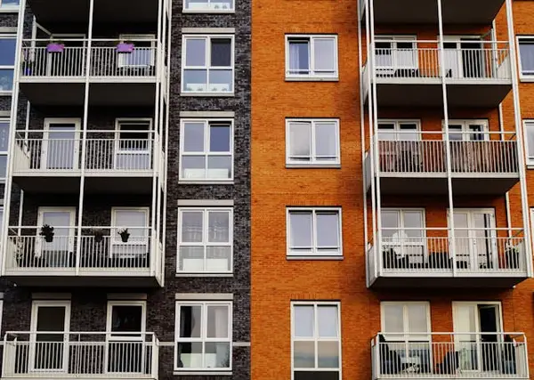 Modern apartment building facade with balconies, highlighting the importance of security guard services for residential communities