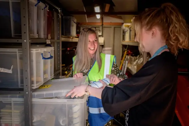 Two individuals in a warehouse with storage boxes, emphasizing the importance of warehouse security guard services