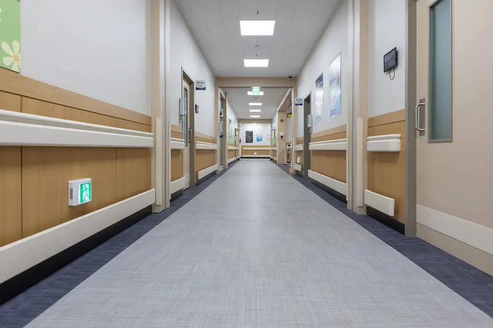 Hospital corridor with light walls and doors, highlighting the importance of hospital security guard services
