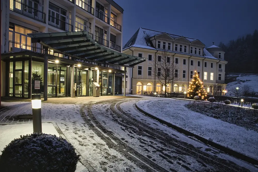 Hotel building at dusk with Christmas tree in snowy setting, highlighting the importance of hotel security guard services