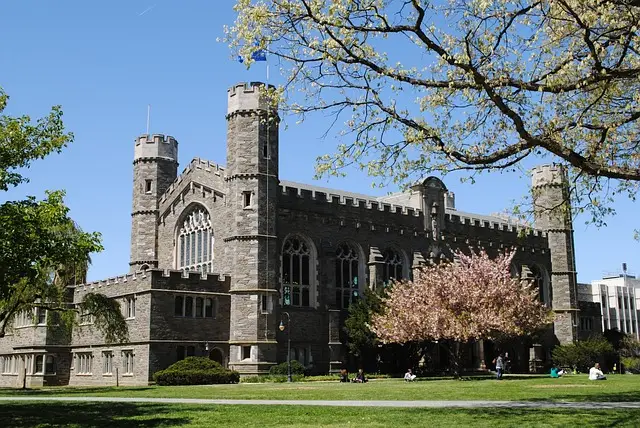 Gothic stone building with arched windows and blossoming trees, emphasizing the importance of campus security guard services