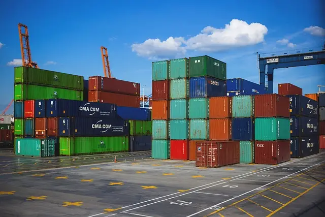 Stack of multicolored shipping containers at cargo port, highlighting the need for logistics security guard services