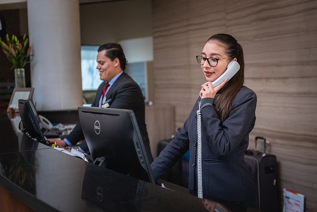 Two individuals at hotel reception desk, highlighting the need for hotel security guard services