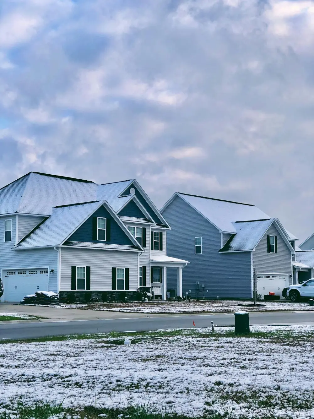 Two-story houses with snowy roofs in residential area, emphasizing the importance of residential security guard services