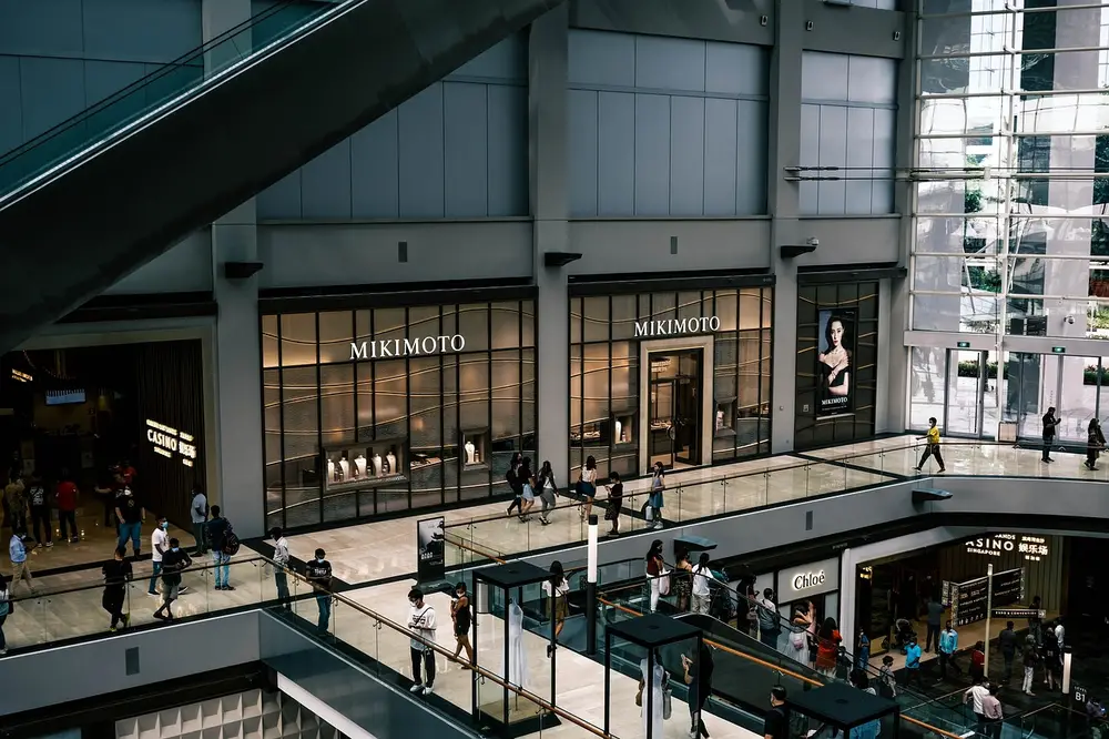 Multi-level shopping mall with escalators and glass storefronts, highlighting the importance of retail security services